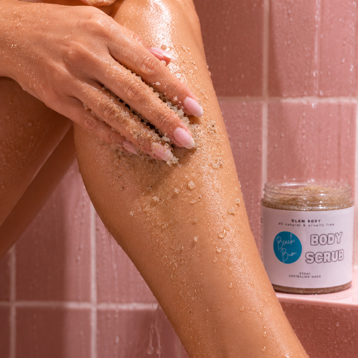 Person using body scrub on leg with a jar of scrub in the background