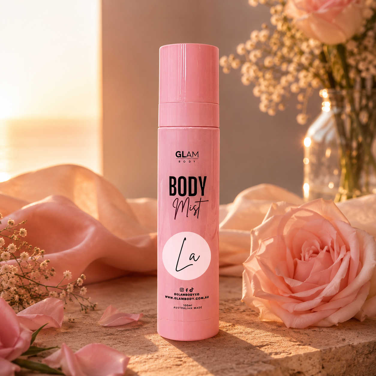 Pink 'GLAM BODY' body mist bottle with flowers and soft lighting