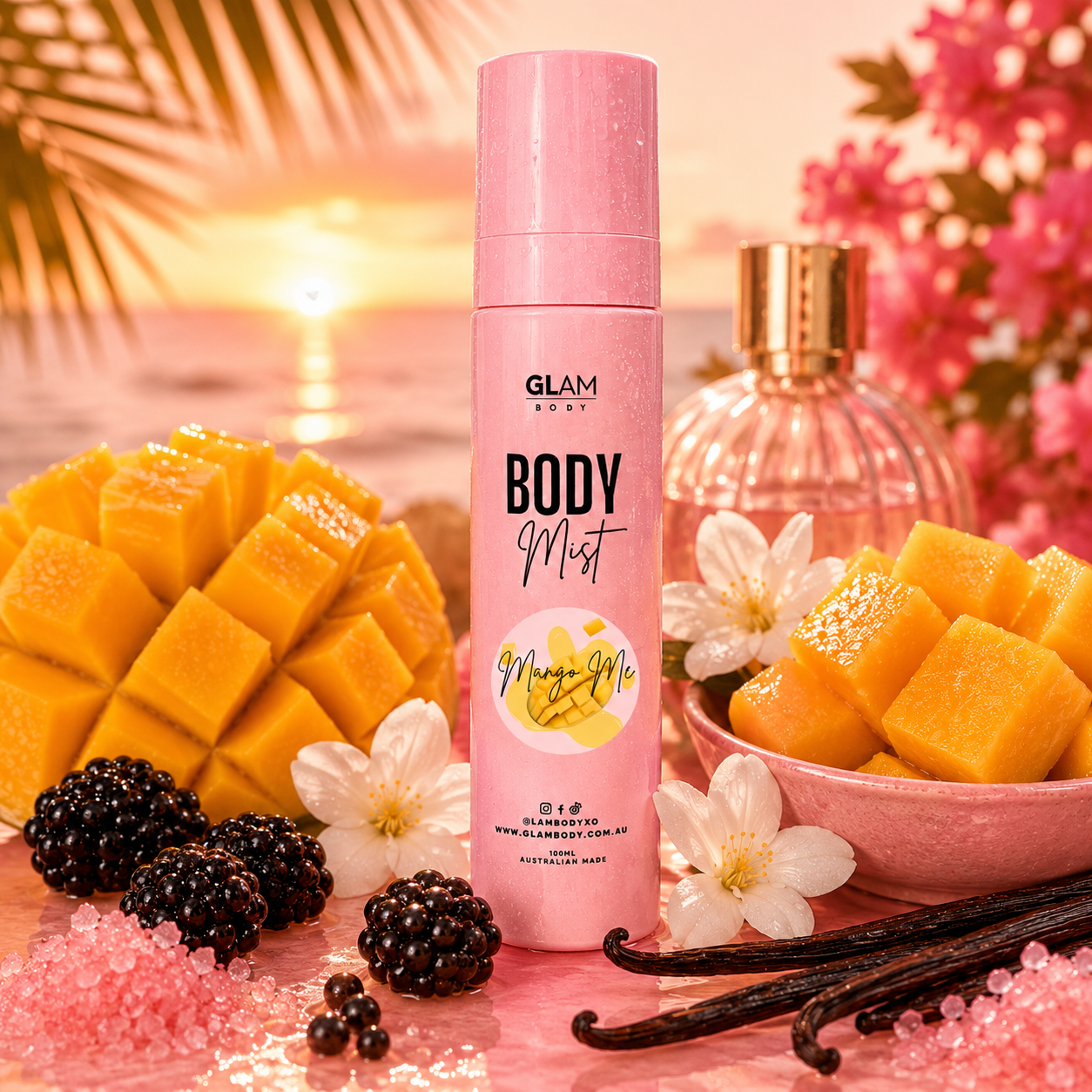 Pink 'Glam Body' body mist bottle with mangoes, flowers, and vanilla beans on a decorative background.