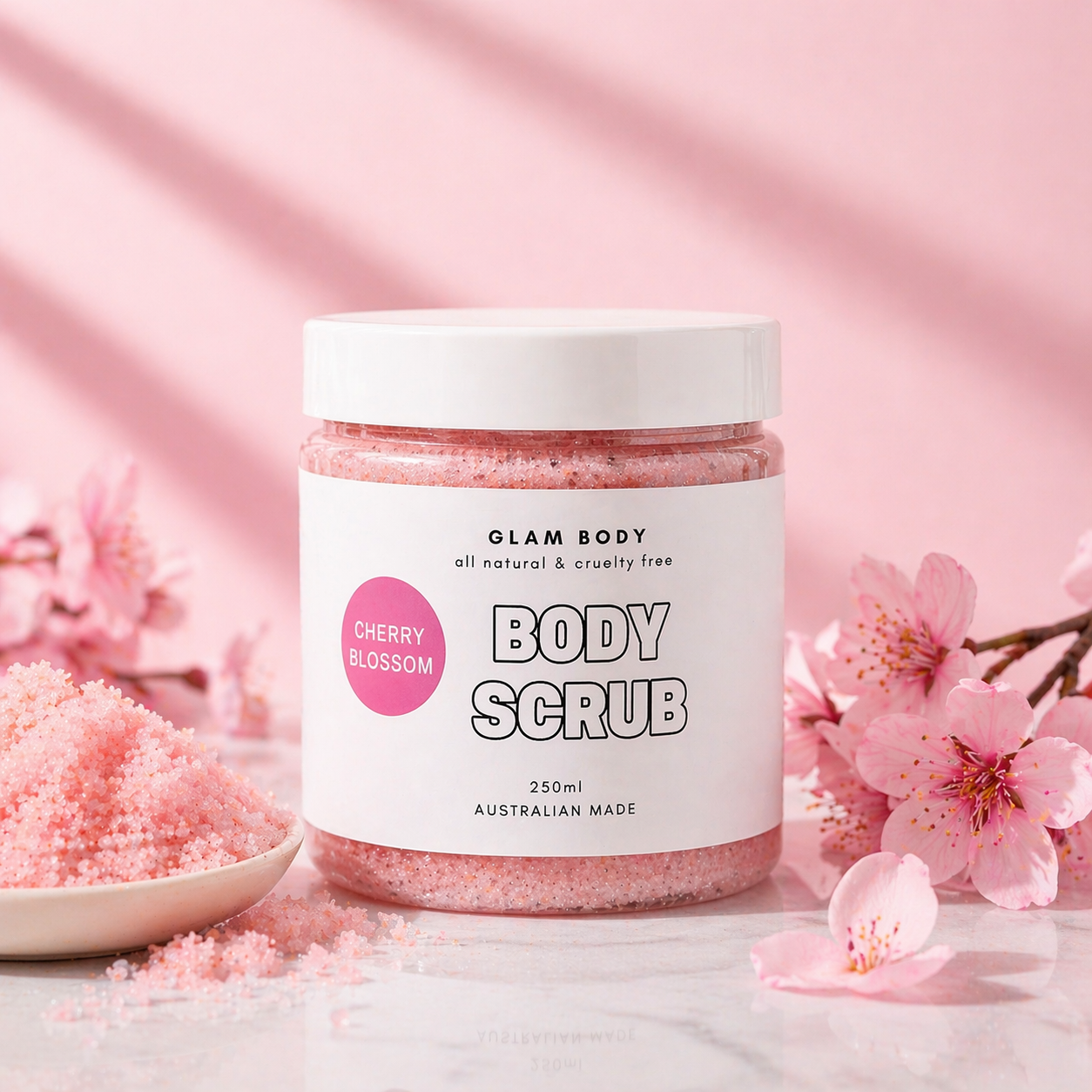 Jar of Glam Body Cherry Blossom body scrub with cherry blossoms in the background