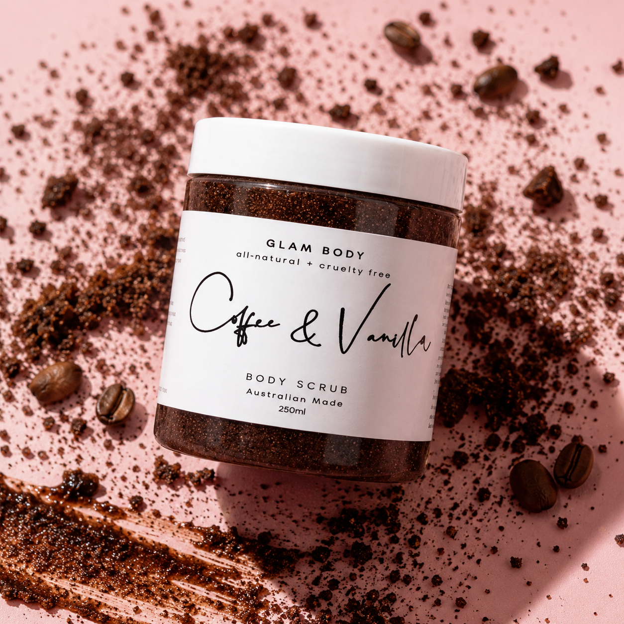 Jar of Glam Body Coffee & Vanilla body scrub on a pink background with coffee beans.