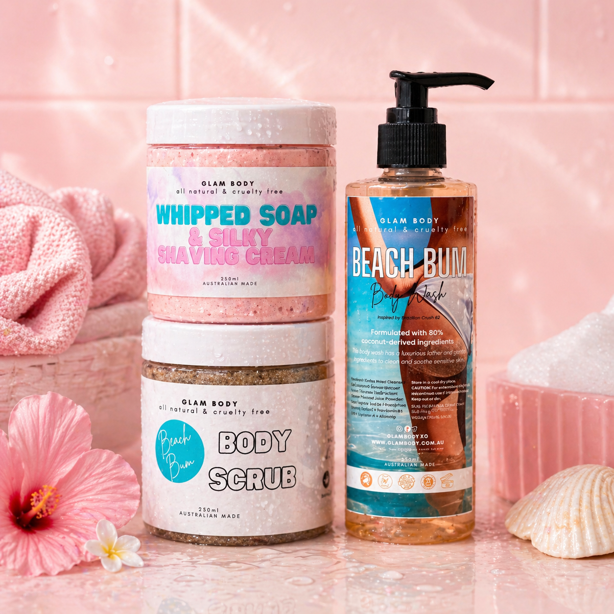 Glam Body skincare products including whipped soap, shaving cream, body scrub, and beach bum lotion on a pink background.