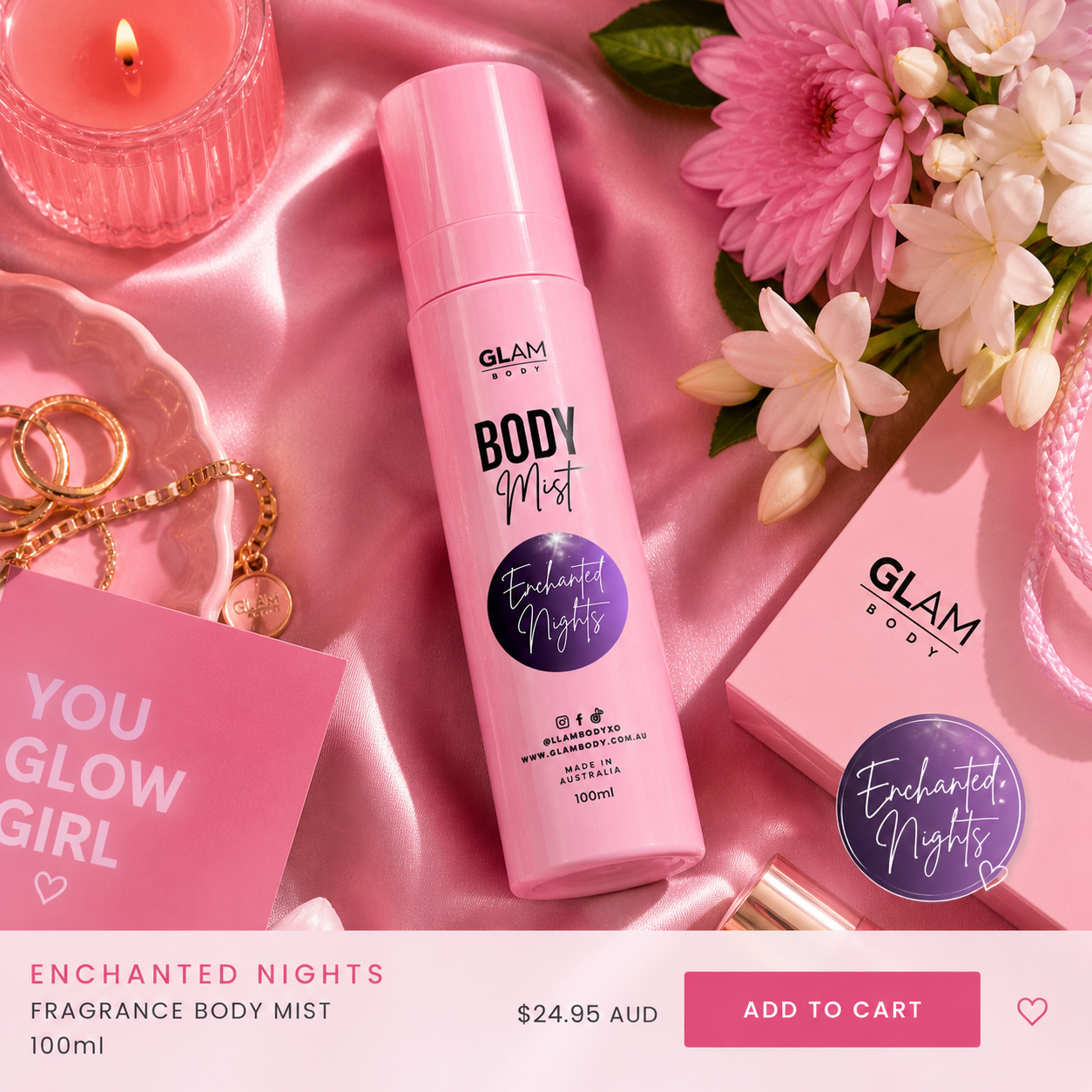 Pink 'Glam Body' fragrance body mist bottle with flowers, card, and candle on pink fabric