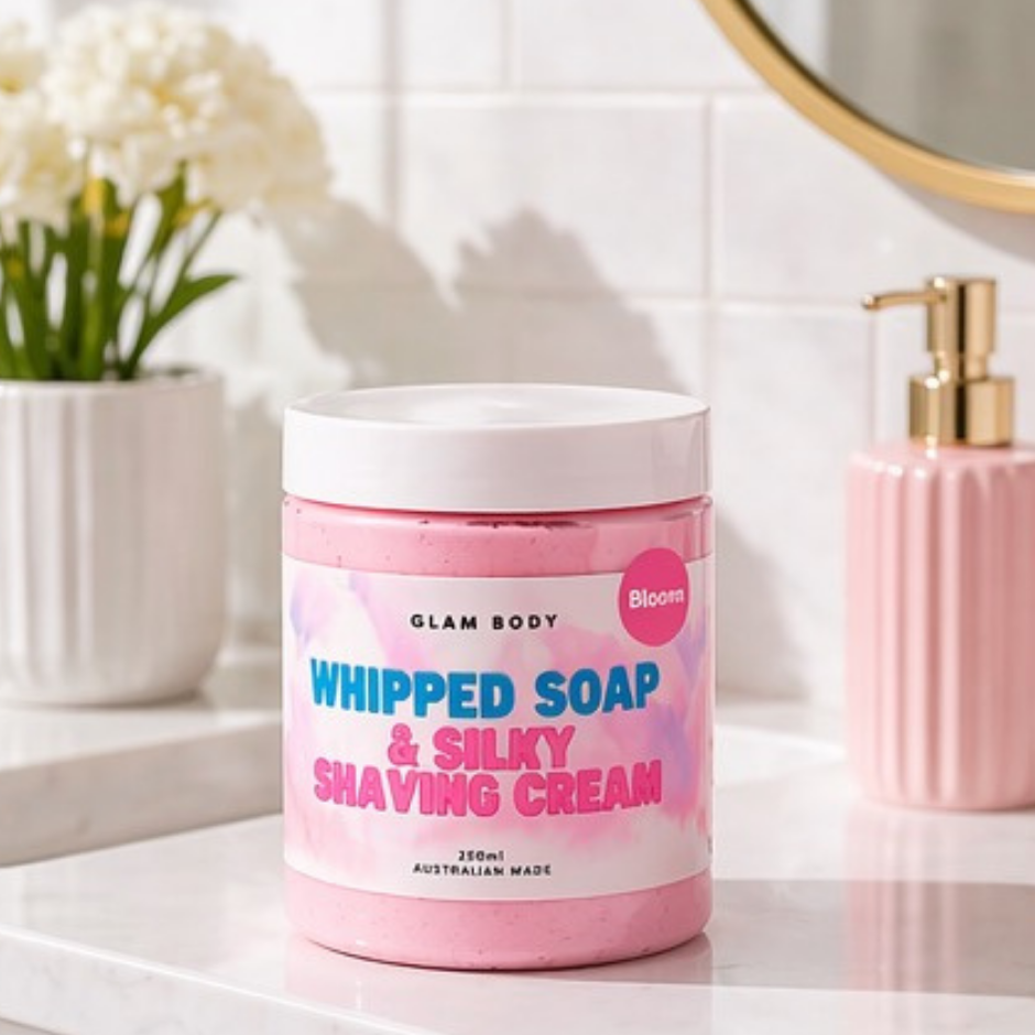 Pink jar of 'Whipped Soap & Silky Shaving Cream' by Glam Body on a bathroom counter.