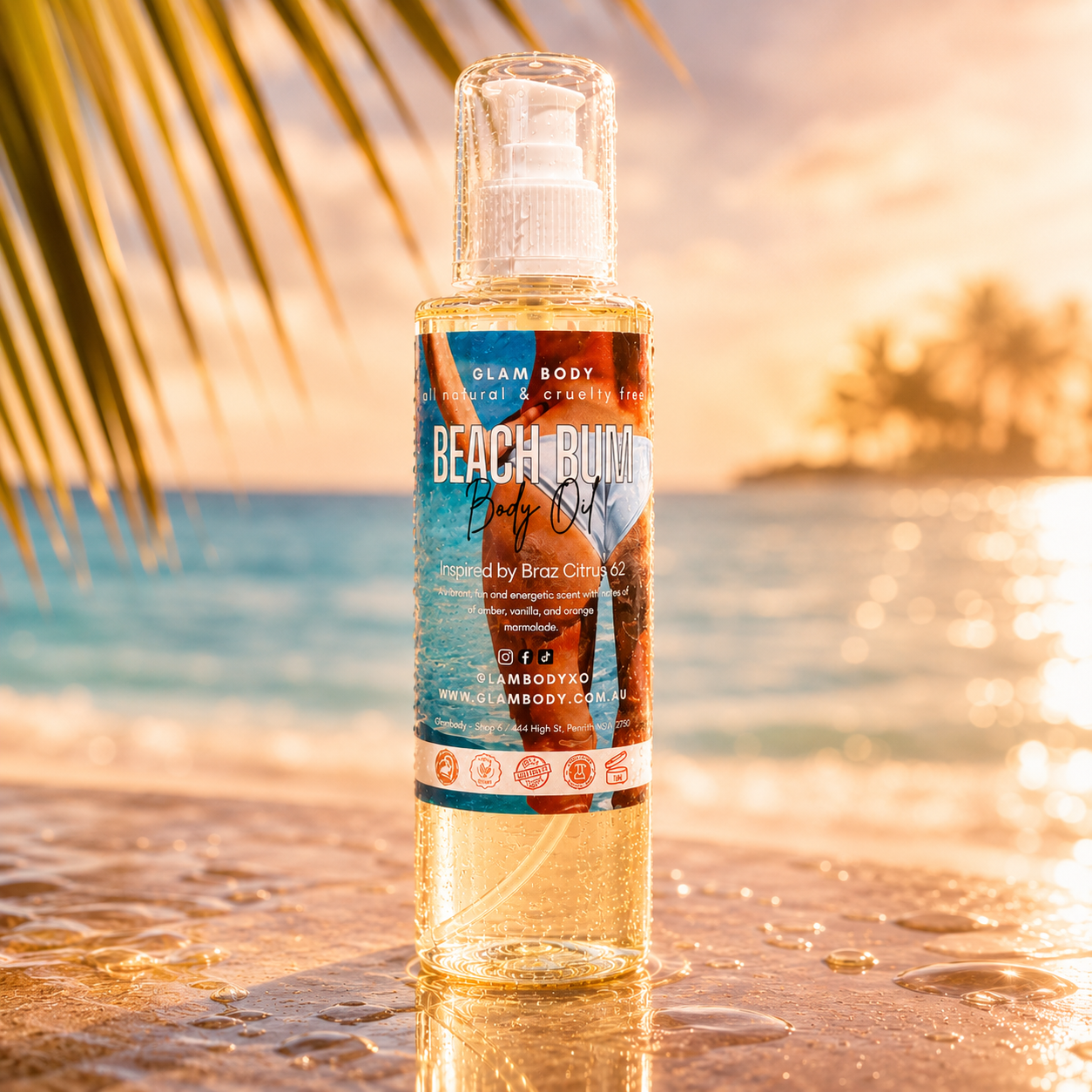 Bottle of Beach Bum Baby Oil on a beach with palm leaves and sunset in the background