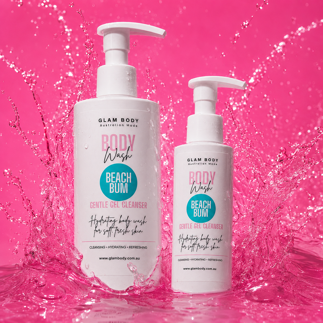 Two white pump bottles of Glam Body Beach Bum body wash, one large and one small, set against a vibrant pink splash background.