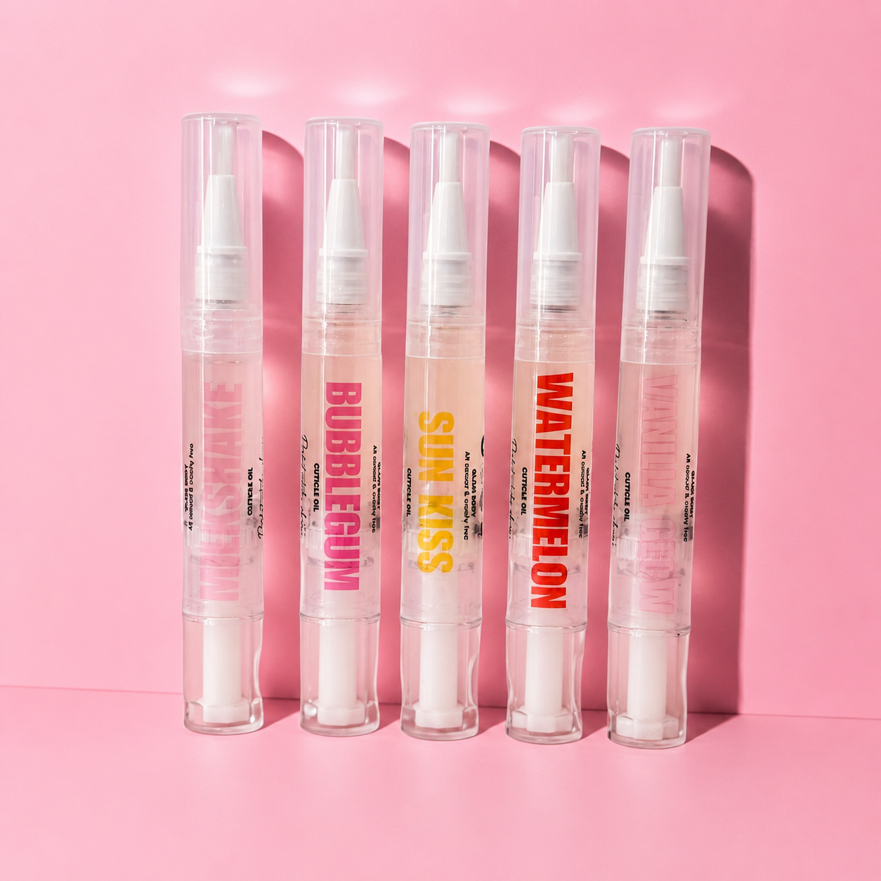 Five transparent lip gloss tubes with colorful text on a pink background