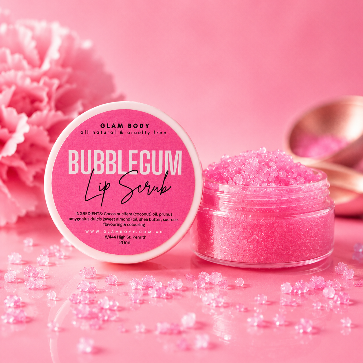 Pink bubblegum lip scrub with packaging on a pink background