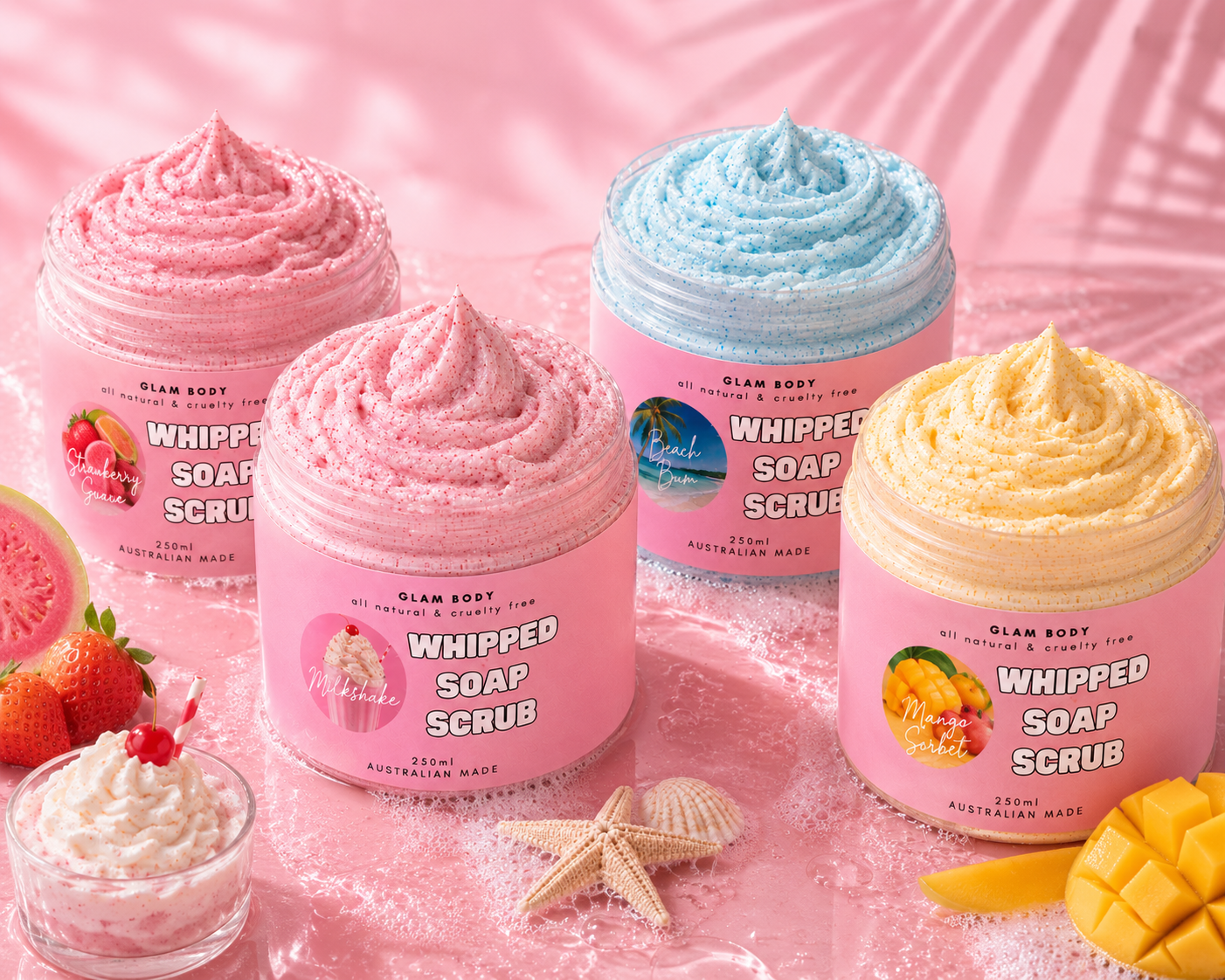 Four jars of whipped soap scrub in pink, blue, and yellow on a pink background with fruits and starfish.