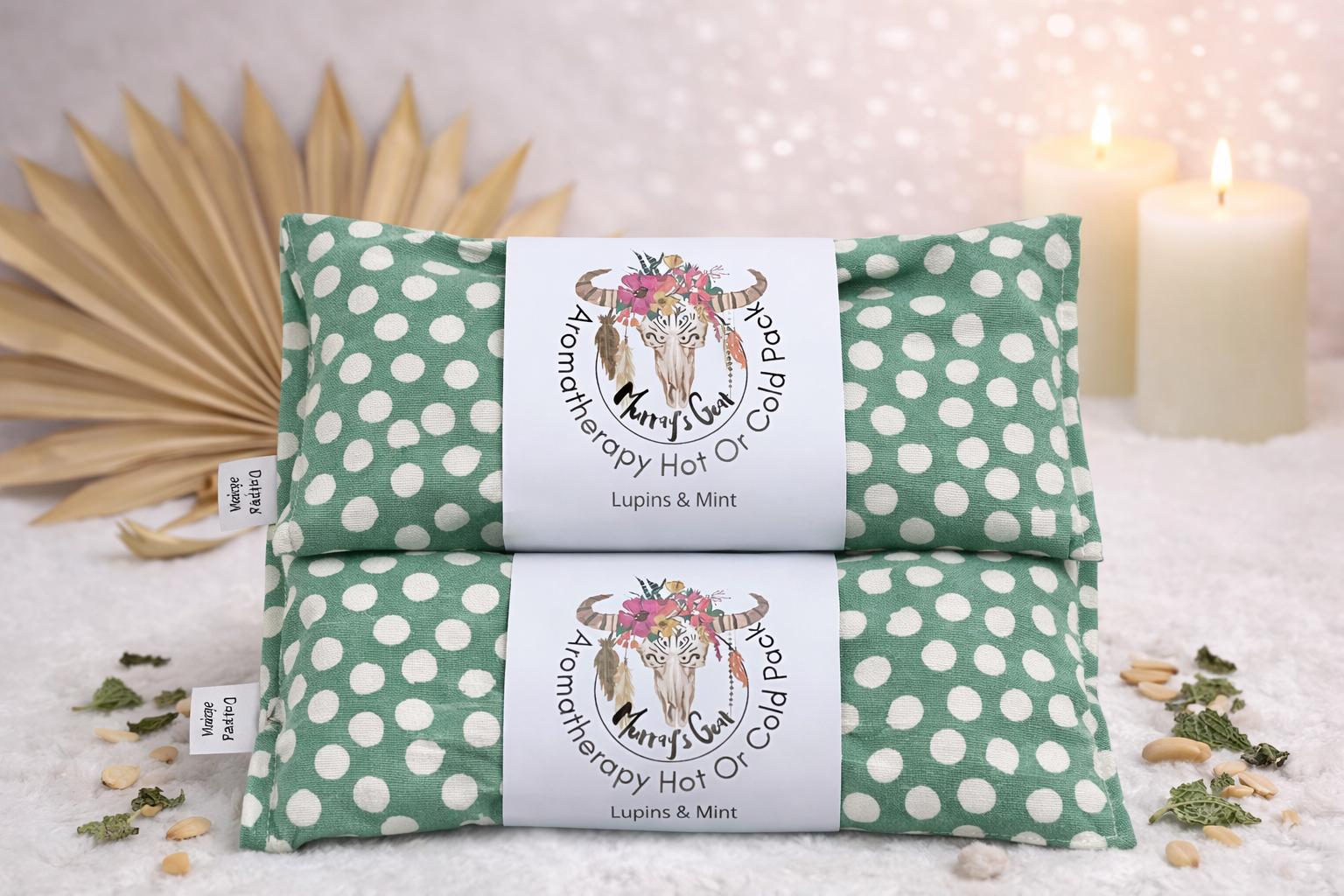 Two green and white polka dot hot or cold packs with labels on a soft surface.