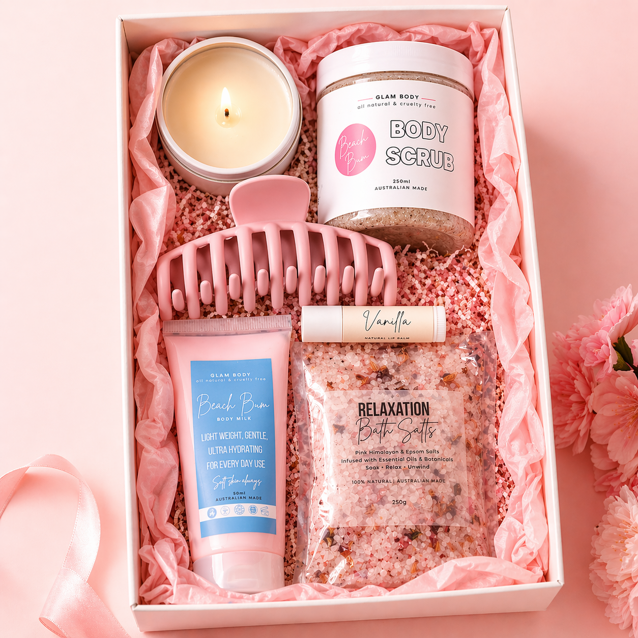 Glam Body gift set with body scrub, bath salts, candle, and body lotion in a pink box.
