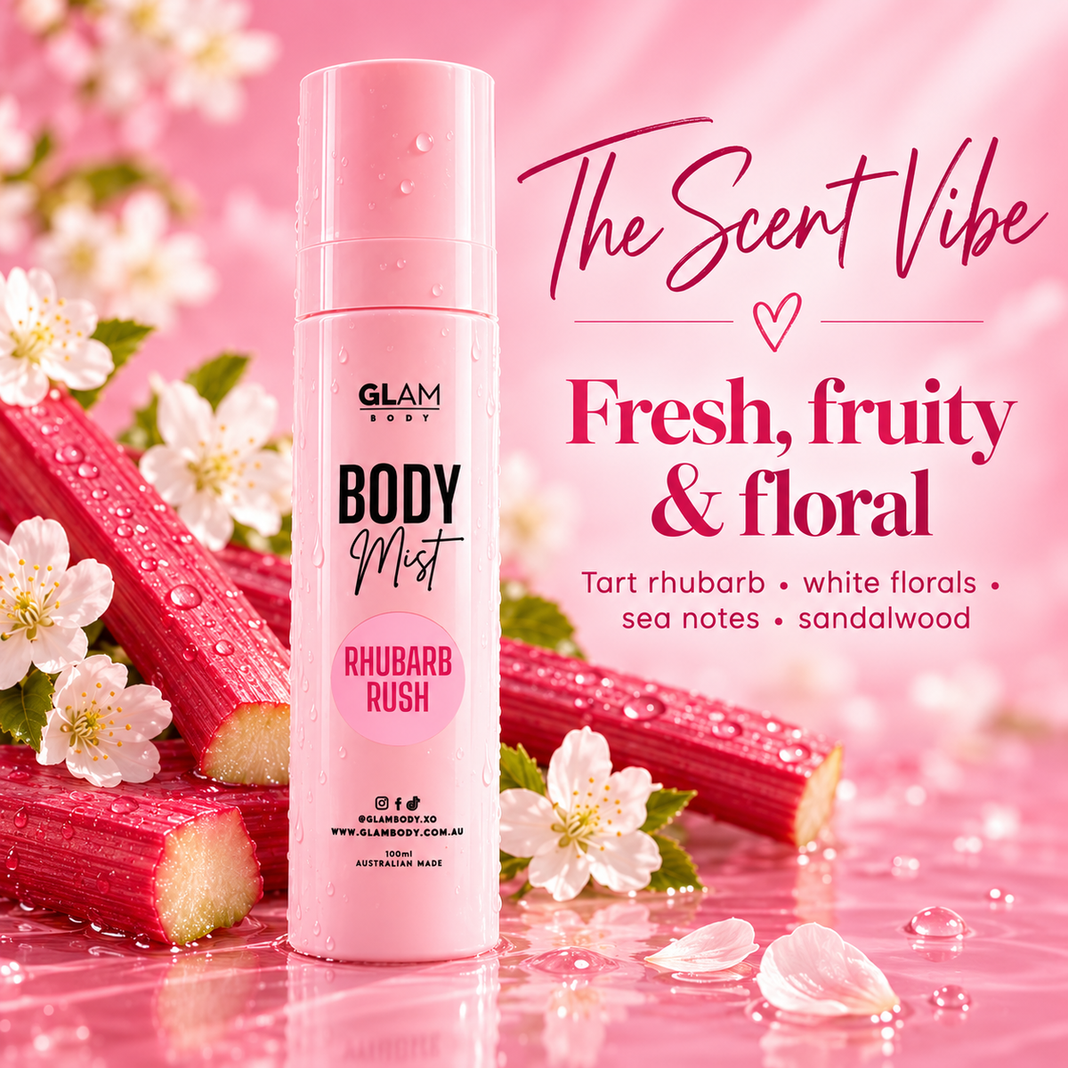 A pink cylindrical body mist bottle labeled 'GLAM BODY BODY Mist RHUBARB RUSH' stands on a glossy pink surface with rhubarb stalks, white flowers, and petals around it. Large pink text on the right reads 'The Scent Vibe' and 'Fresh, fruity & floral' with scent notes.