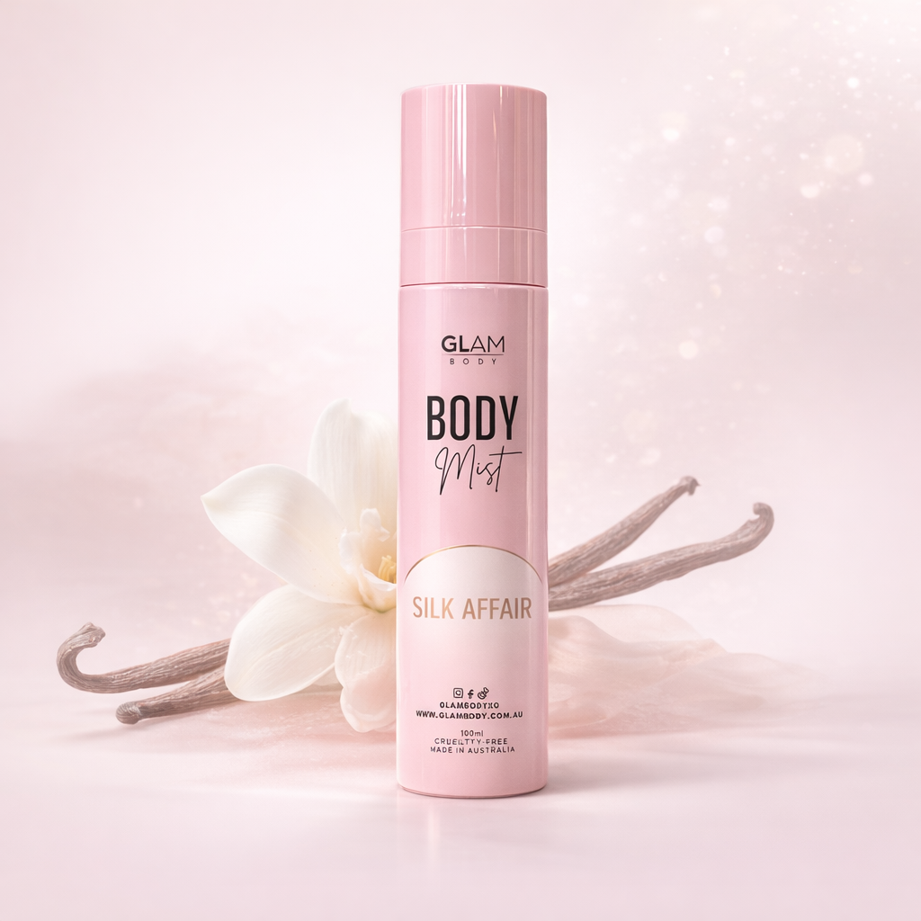 Pink 'Glam Body' body mist bottle with vanilla beans and flowers on a light pink background