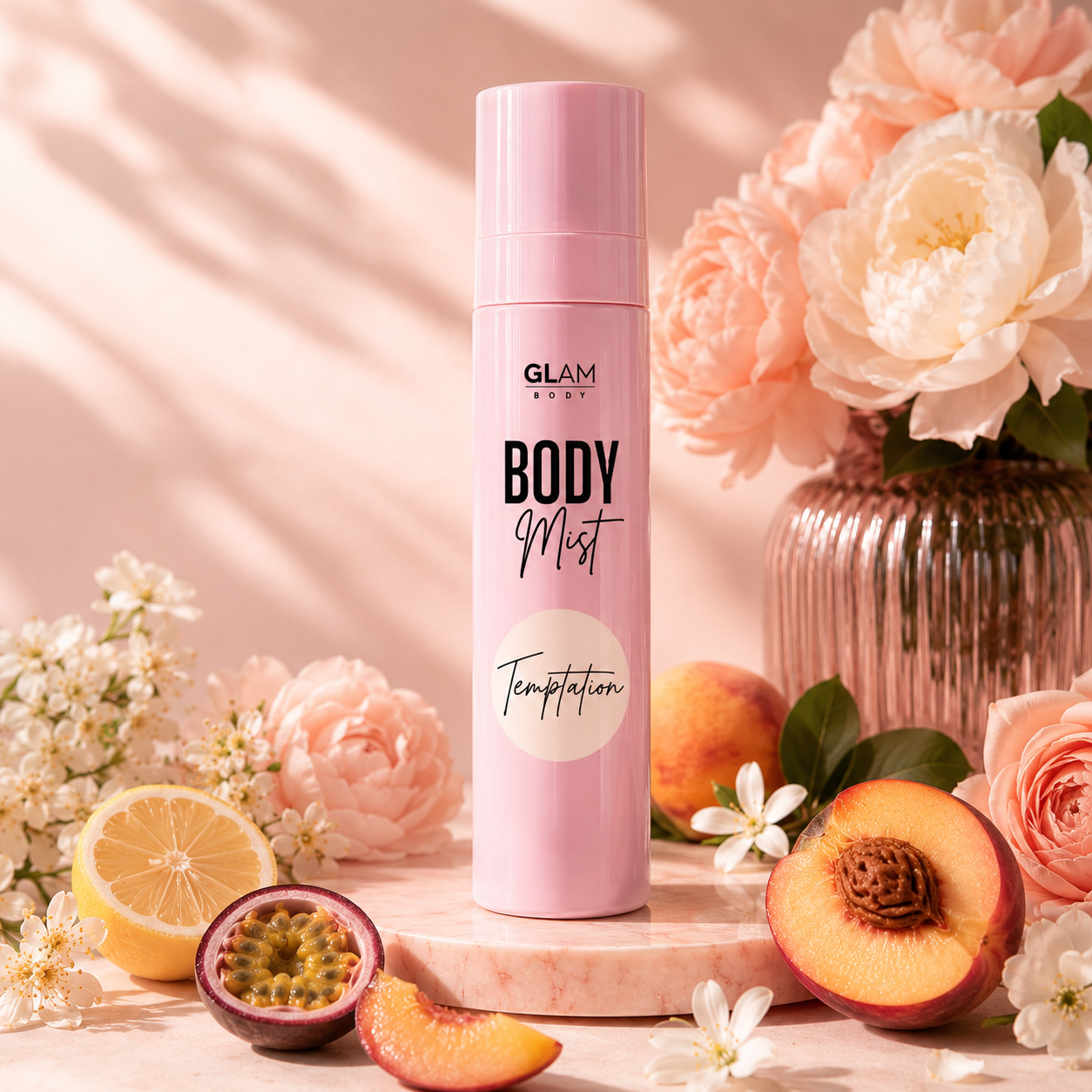 Pink 'GLAM BODY' body mist bottle with flowers, peaches, and lemons on a pink background