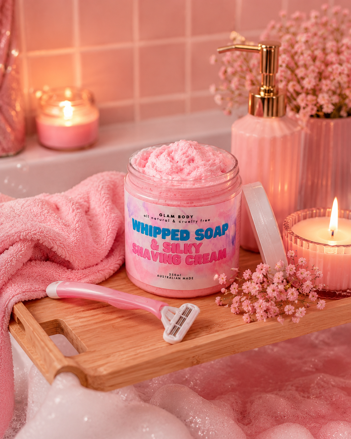 Jar of whipped soap and silky shaving cream on a wooden tray with a razor, candles, and flowers in a bathroom setting.